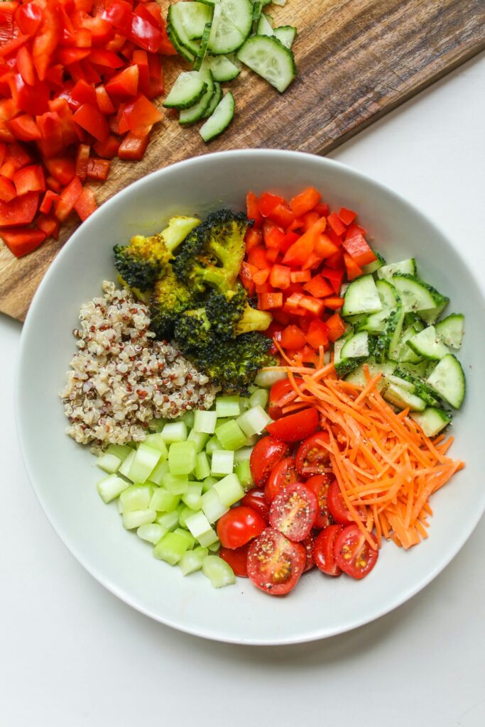 Healthy salad plate featuring mixed greens, tomatoes, cucumbers, and bell peppers