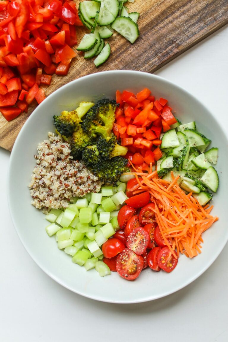 Healthy salad plate featuring mixed greens, tomatoes, cucumbers, and bell peppers
